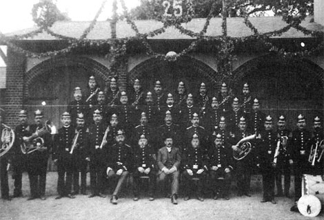 Historische Blaskapelle posiert mit Instrumenten, schwarz-weißes Foto.