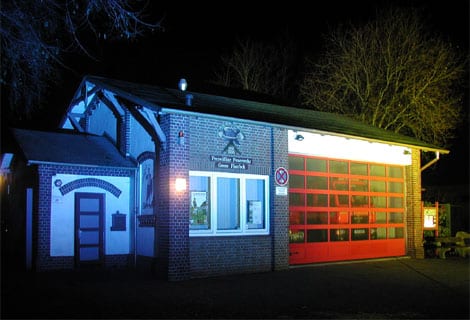 Beleuchtetes Feuerwehrhaus bei Nacht